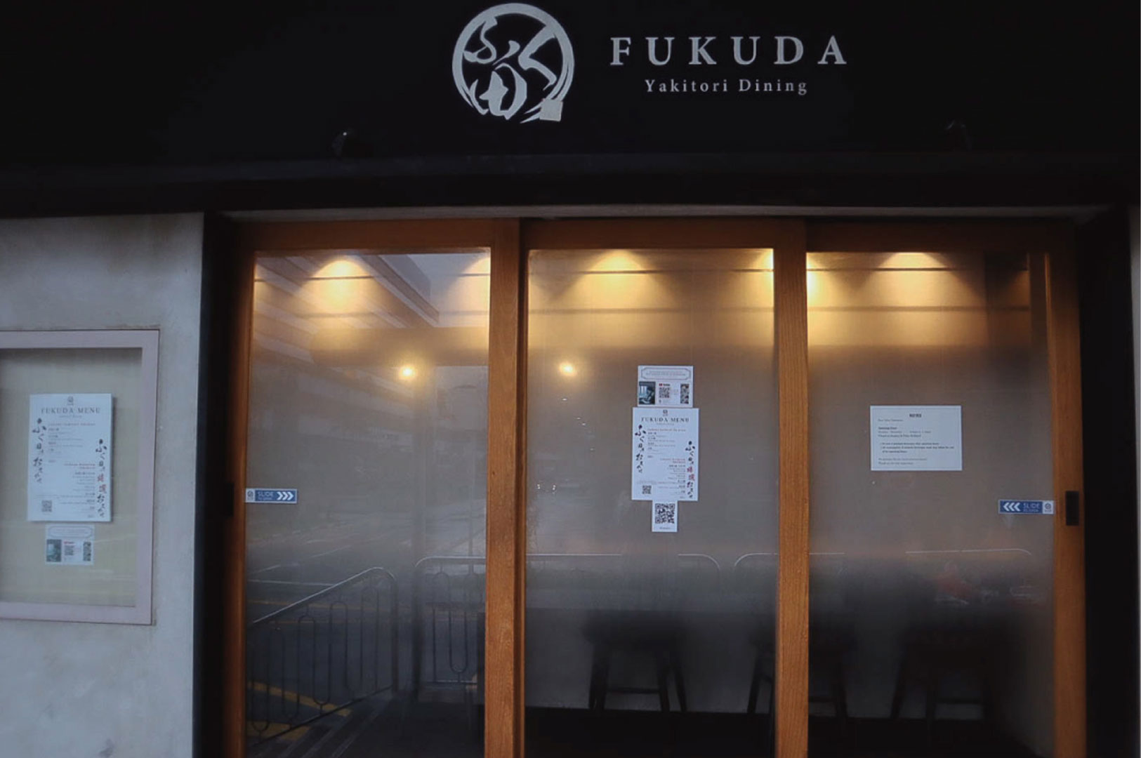 Exterior view of the main entrance to Fukuda Yakitori Dining with the logo and dark signage.