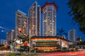 Night view of the iconic Singapore Marriott Tang Plaza Hotel featuring its distinctive octagonal pagoda-style roof and illuminated architecture on Orchard Road.