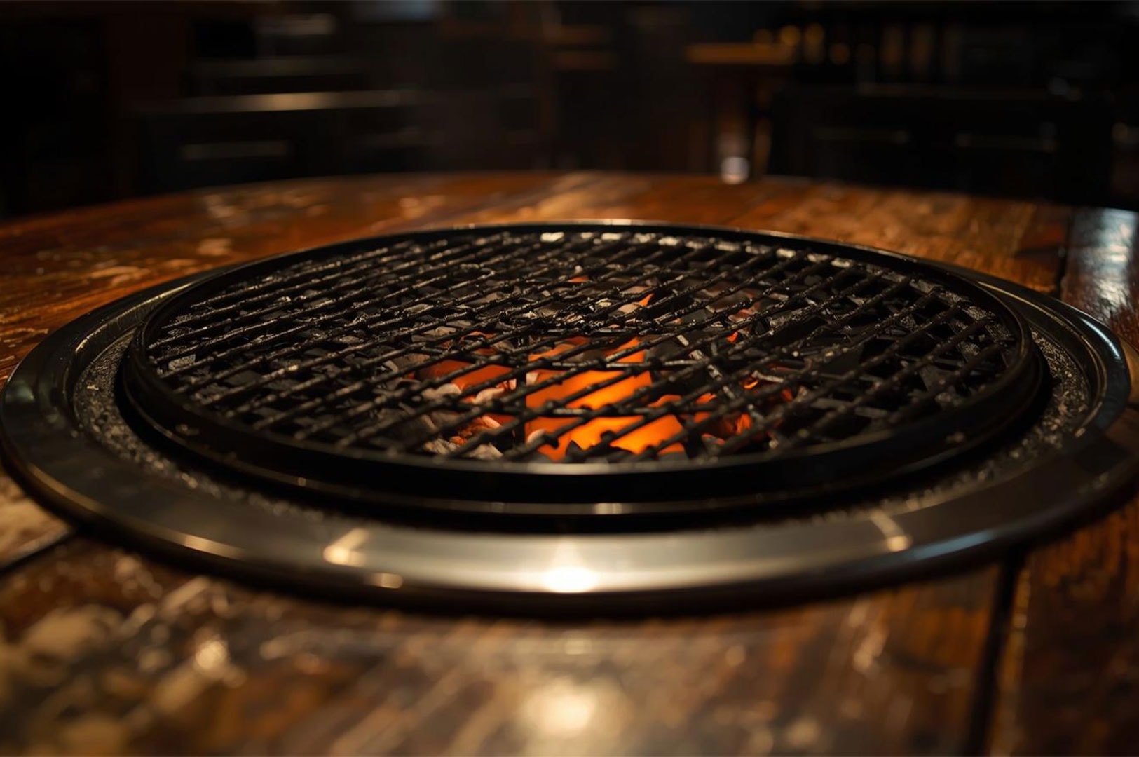 A low-angle, close-up shot of a clean metal grill grate sitting over glowing hot charcoal embers, ready for Yakiniku cooking.